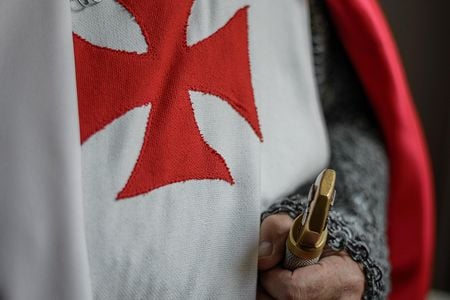 Knights of the SMOTJ wear the red cross pattée, believed to have been first used by the Knights Templar in 1147.
