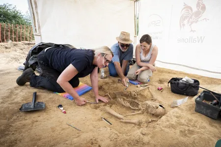 Archaeologists carefully brush away dirt from the skeleton.