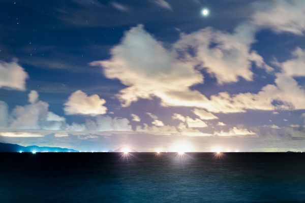 Stars, lights, clouds and fishing at Night thumbnail