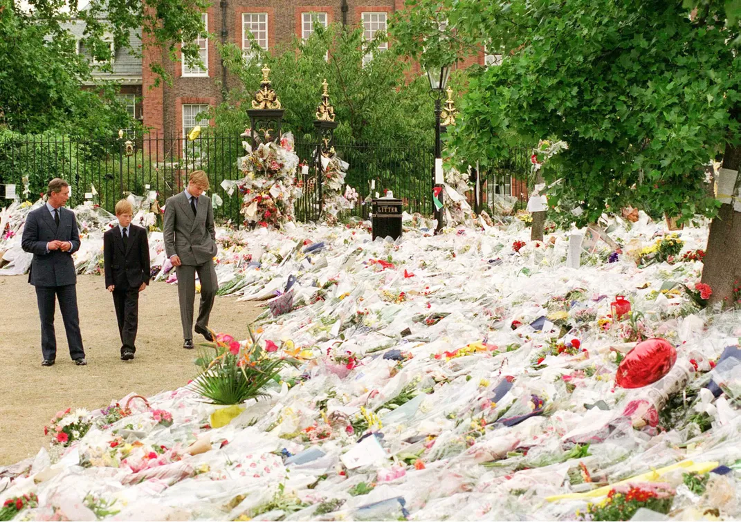 Charles, Harry and William look at flowers left at Kensington Palace following Diana's death.