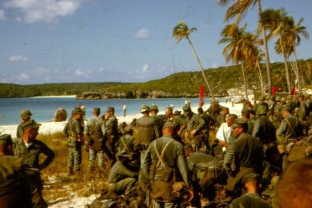 “Sweaty troops on the beach prepare to move out.”