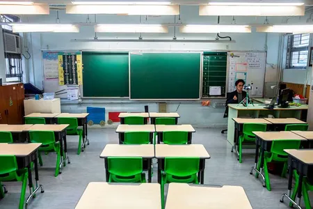 In this photo taken on March 6, 2020, primary school teacher Billy Yeung records a video lesson for his students, who have had their classes suspended due to coronavirus, in his empty classroom in Hong Kong.