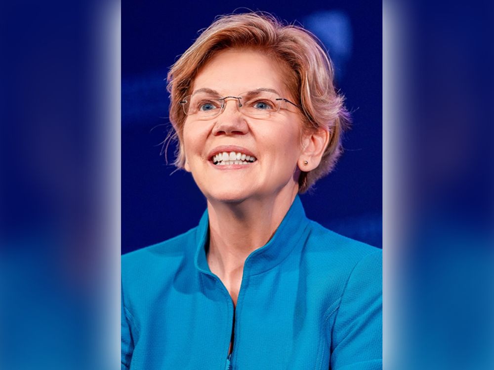Image of a woman, Elizabeth Warren, smiling in a blue shirt