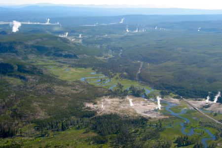 Plumes of steam rise up from many spots along the Firehole River in Yellowstone National Park.