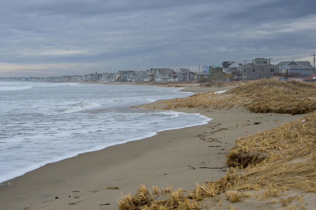 A photograph shows Wells Beach in southern Maine with beach houses on the horizon