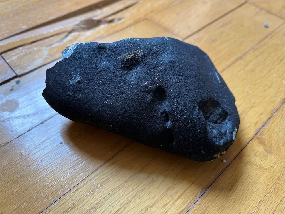close-up of a black rock on a hardwood floor