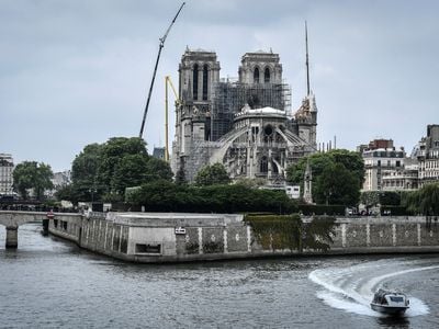 A police boat cruises along the River Seine past the Notre-Dame de Paris Cathedral, which was badly damaged by a huge fire on April 15, and which is under repair, on May 20, 2019.