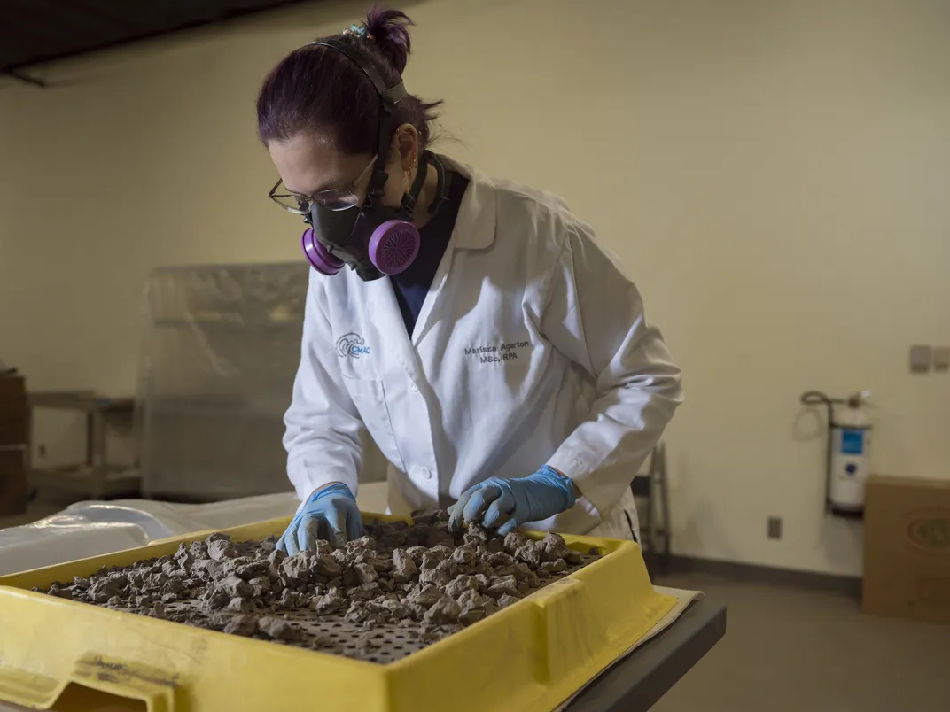 Agerton sifts through silt, mud and historical matter that was found while examining and cleaning the boat.