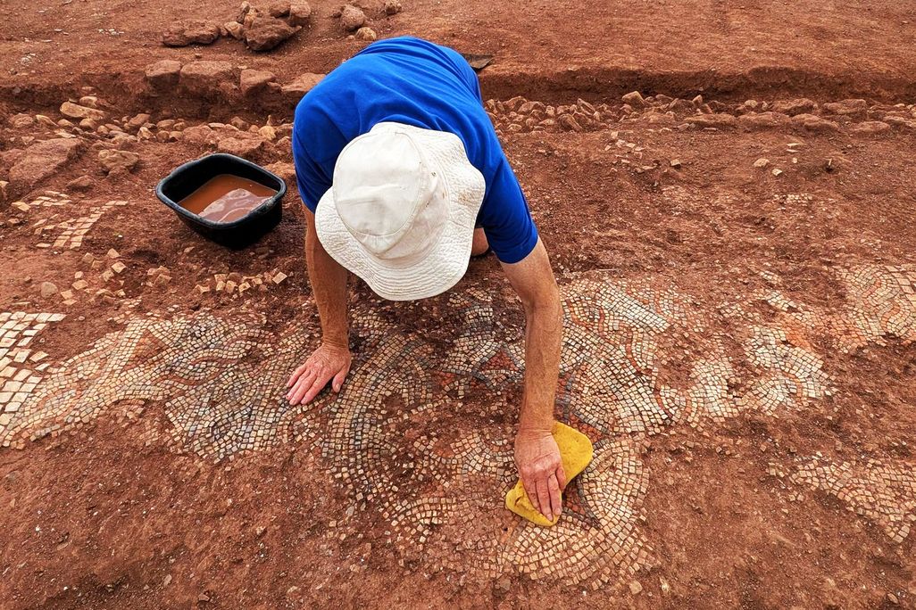Person excavating Roman mosaic