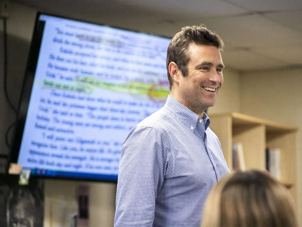 Man stands in front of screen with a chapter of a book on it and highlighted text