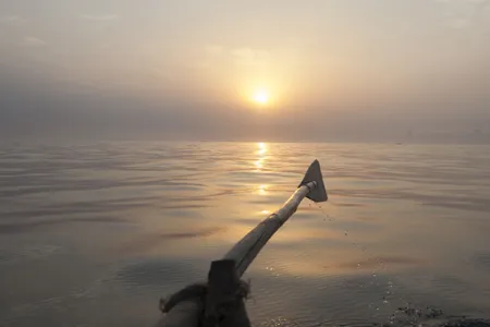 Indian fishermen row their boat on the Bay of Bengal.