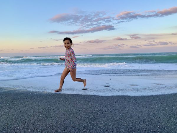 Child playing and running from waves thumbnail