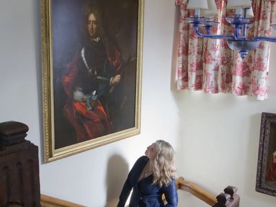 Curator Katherine Carter with the restored Marlborough portrait in Chartwell&#39;s main staircase