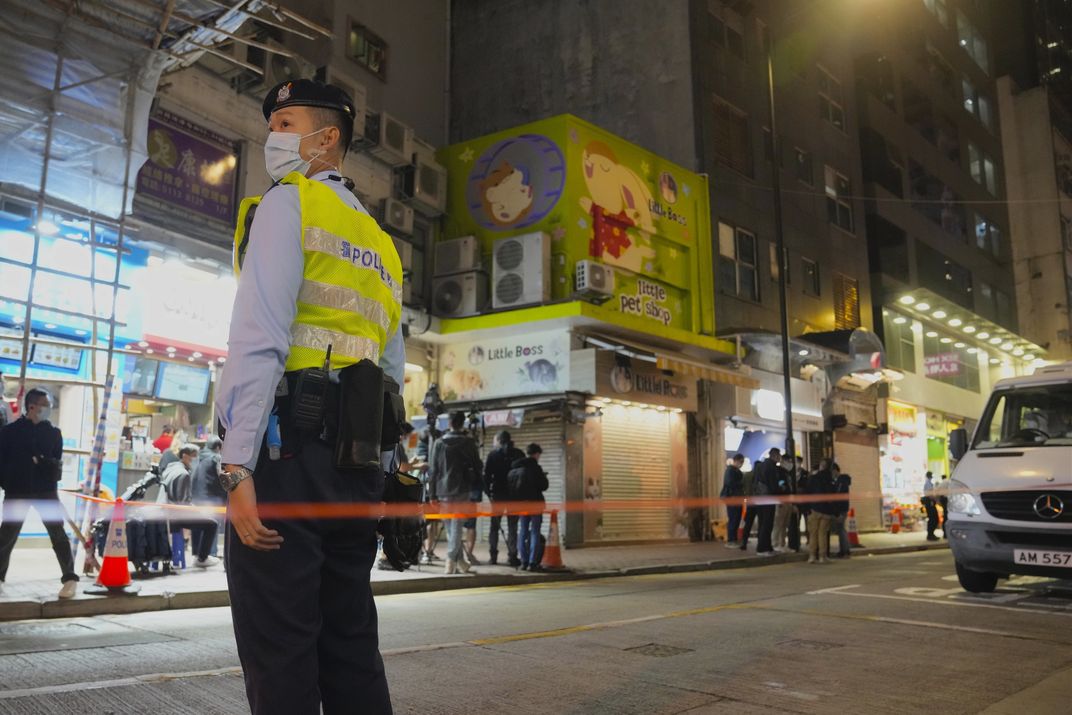 A police officer stands guard outside Little Boss pet store.