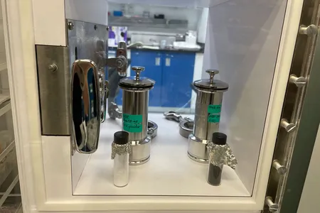 The tinfoil-covered vial at right holds about four grams of an asteroid brought to Earth from deep space. It may also hold the key to how life began here. The vial at left holds ground-up quartz that will act as a control in chemical investigations.