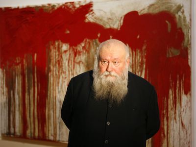 Hermann Nitsch pictured in front of one of his works at a 2006 retrospective.