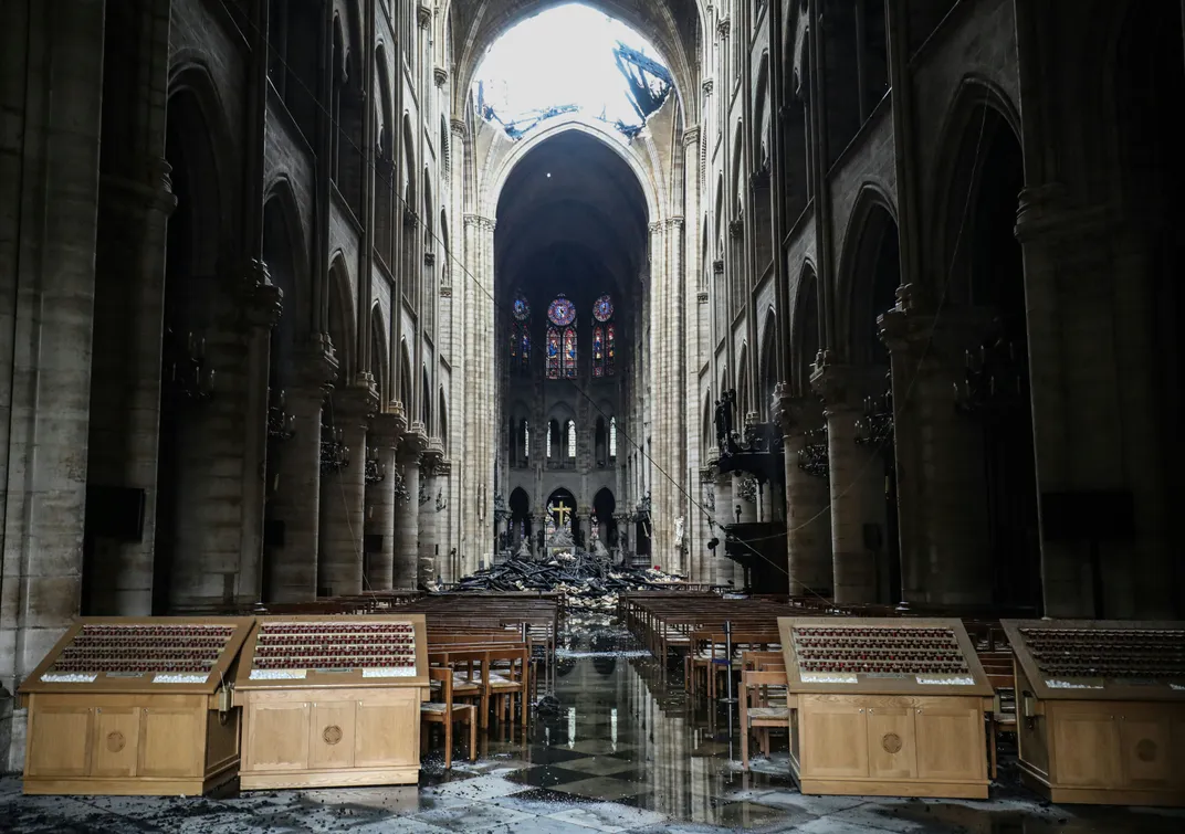 A shot of the interior of the cathedral in April 2019 shows debris covering much of the ground, dark smoke and other damage from the fire
