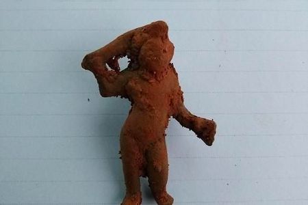 The bronze Cupid figurine carries a flaming torch.