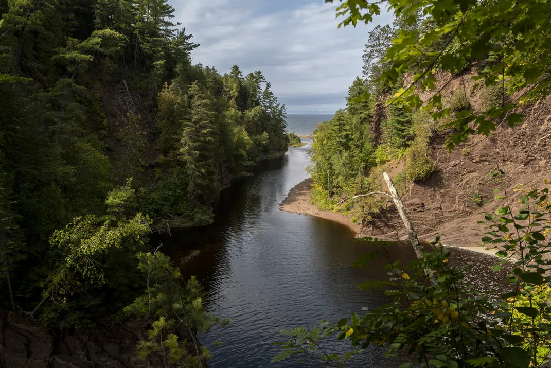 A view of a body of water surrounded by high walls and trees