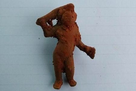 The bronze Cupid figurine carries a flaming torch.