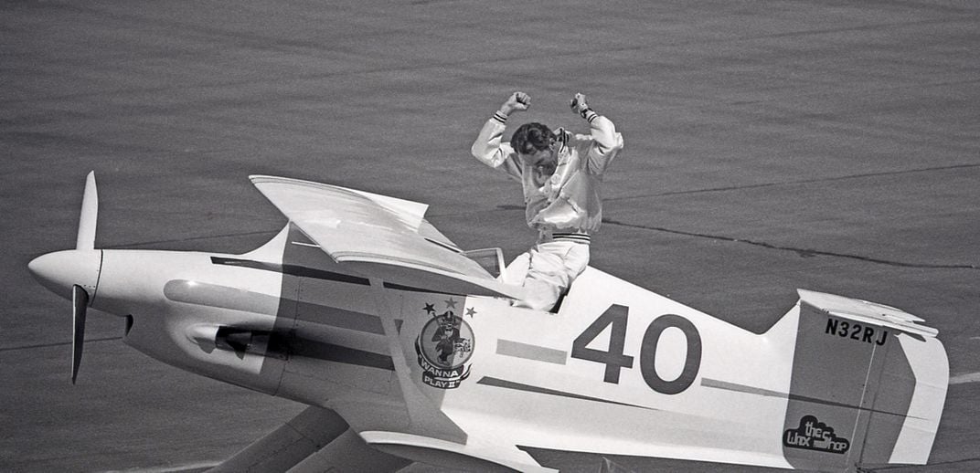 Tom Aberle celebrating next to biplane