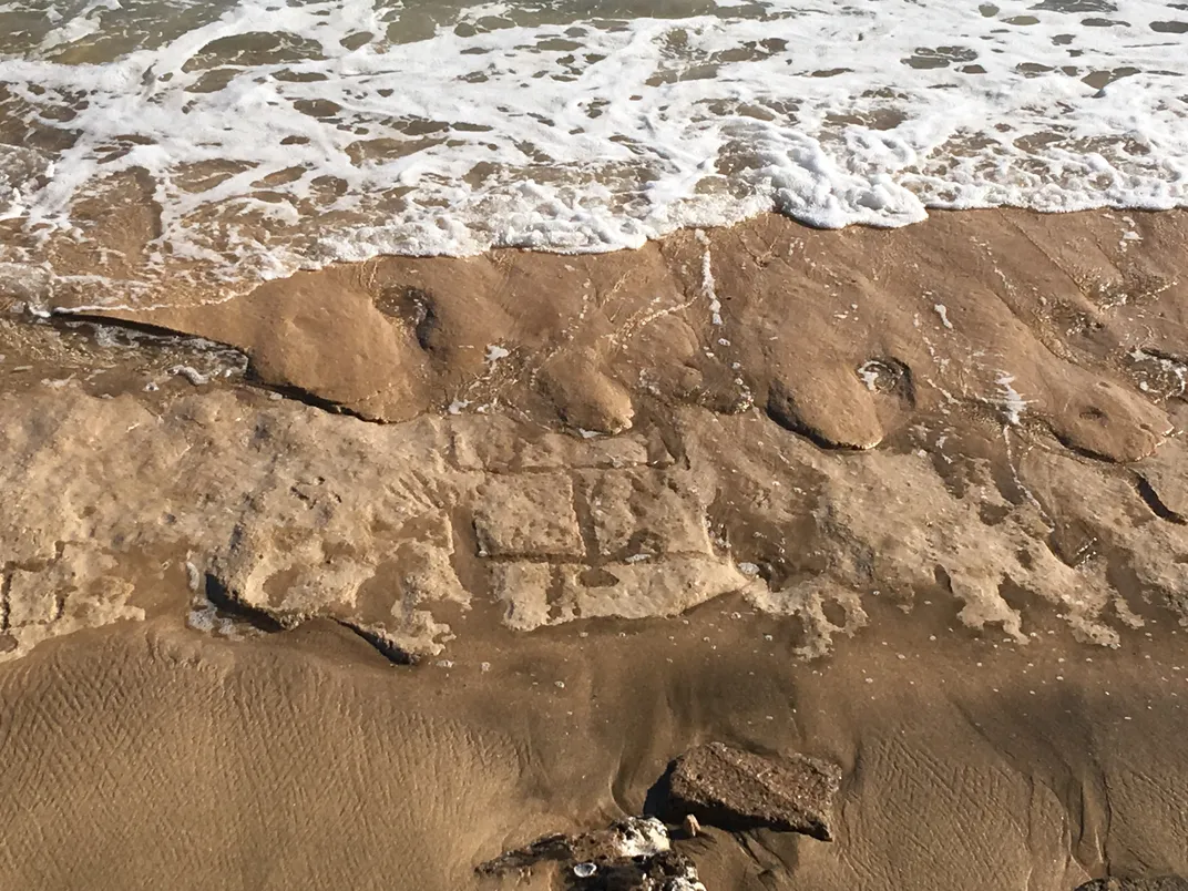 Petroglyph carving on beach next to water