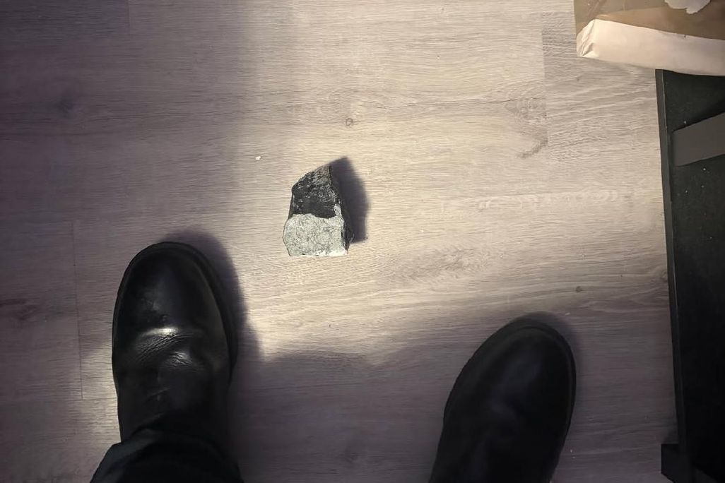 rock on the floor of a house between person's feet