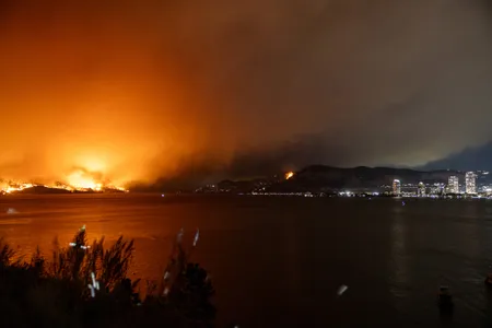The McDougall Creek wildfire burns in the hills of British Columbia, Canada, on August 17, 2023. Evacuation orders were put in place for areas near Kelowna, as the fire threatened the city of around 150,000.