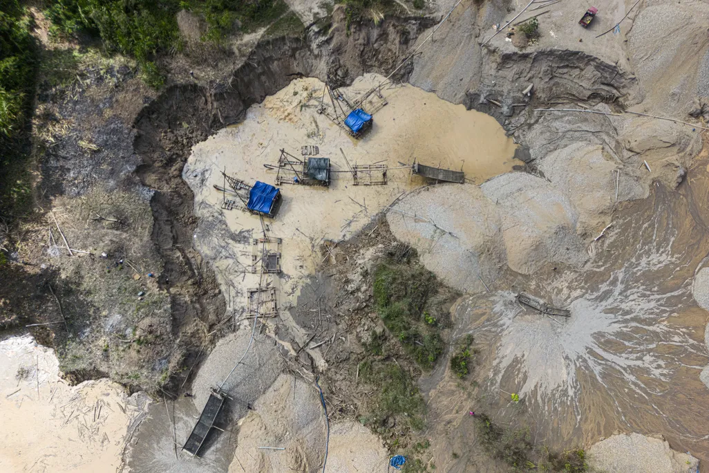 an overhead view of a deforested area with some mining technology set up