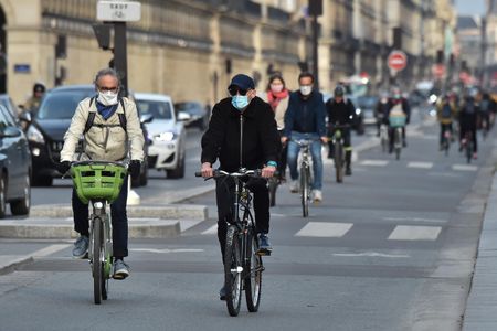 People in France bike wearing masks down the "Rue de Rivoli."
