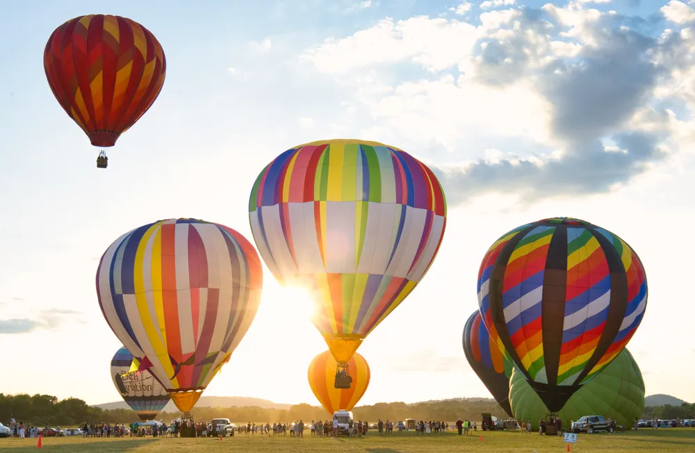 Festivals are such a big part of the American culture. Pictured: Rays of sunlight peeking through hot air balloons as seen at the New Jersey Lottery Festival of Ballooning held at the Solberg Airport in Whitehouse Station, New Jersey.