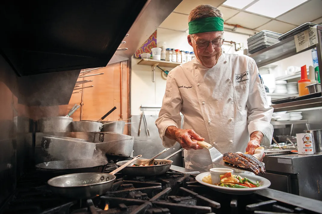A chef plating food in a kitchen