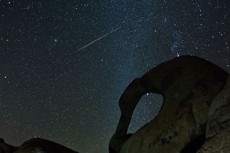 A Geminid meteor streaks through the sky.