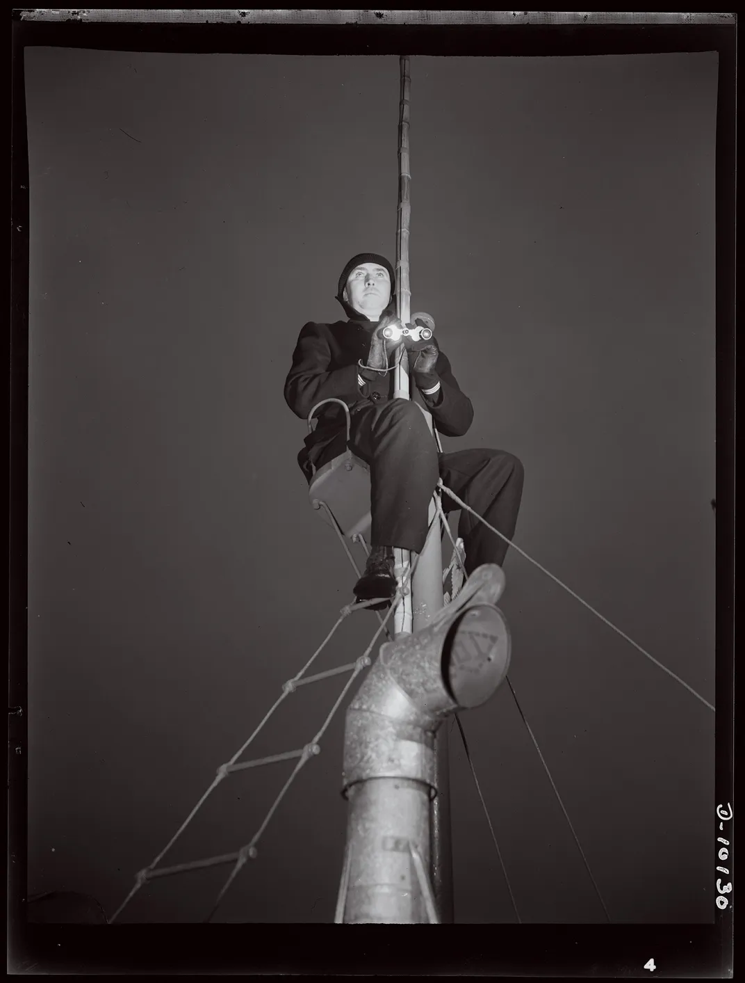 a man on lookout on a sailboat