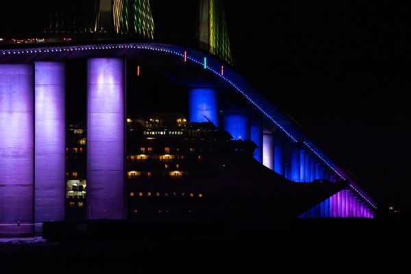 3rd cruise ship to resume cruising from Tampa sails under illuminated Skyway Bridge at night thumbnail