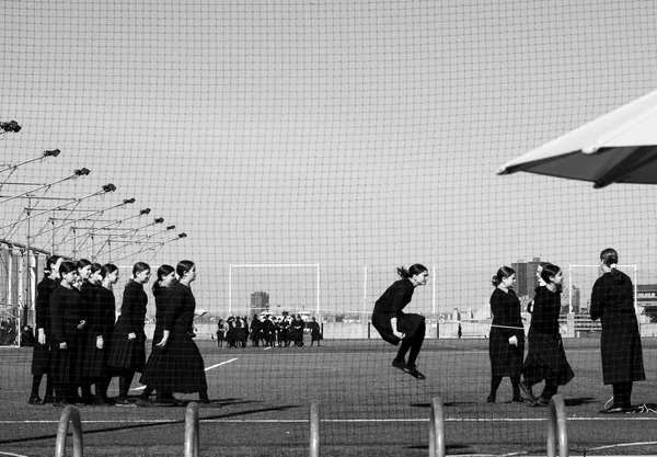 A group of Hassidic Jewish girls skip on a soccer pitch during a religious holiday. thumbnail