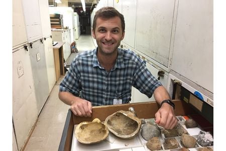 The National Museum of Natural History’s newest curator in the paleobiology department, Dr. Stewart Edie, opens a drawer with mollusk fossils in the museum’s invertebrate paleobiology collection. (Katie Collins, National History Museum, London)