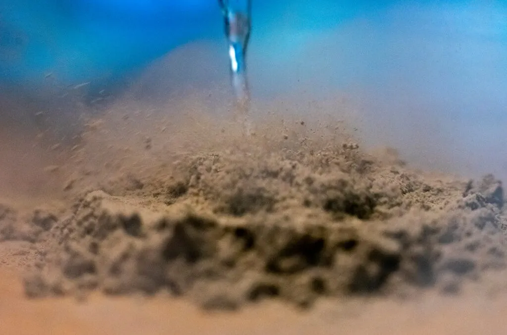 Tannish-brown dust underneath a stream of liquid