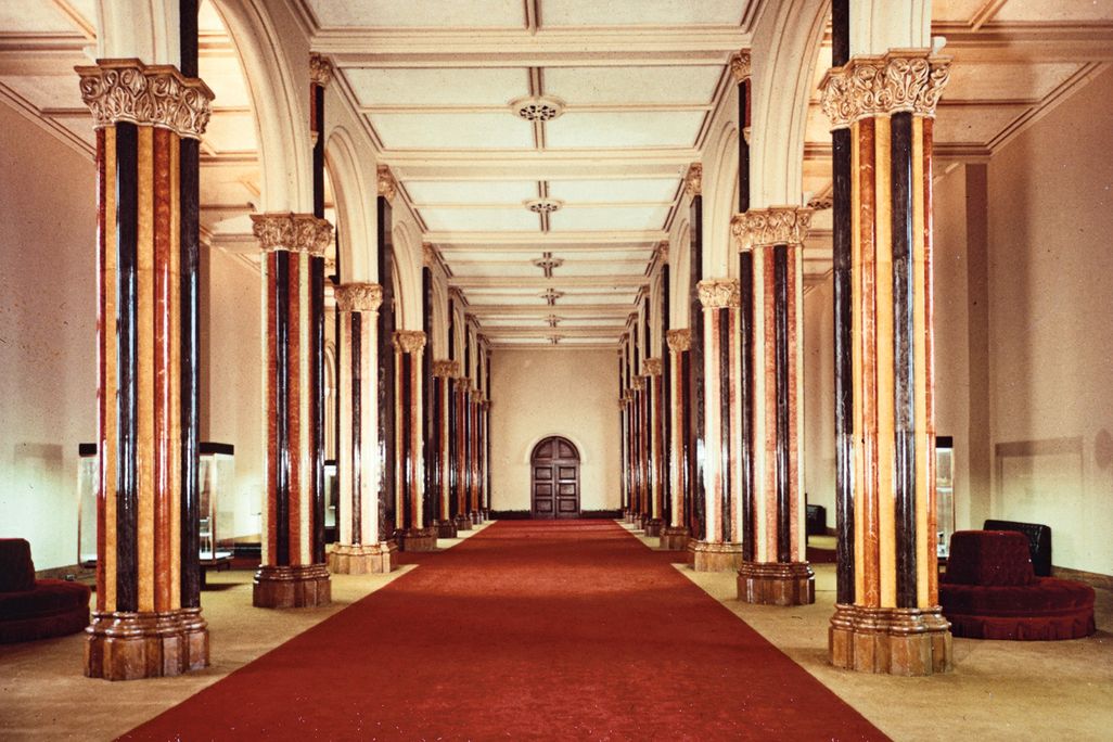a red carpet surrounded by marble columns