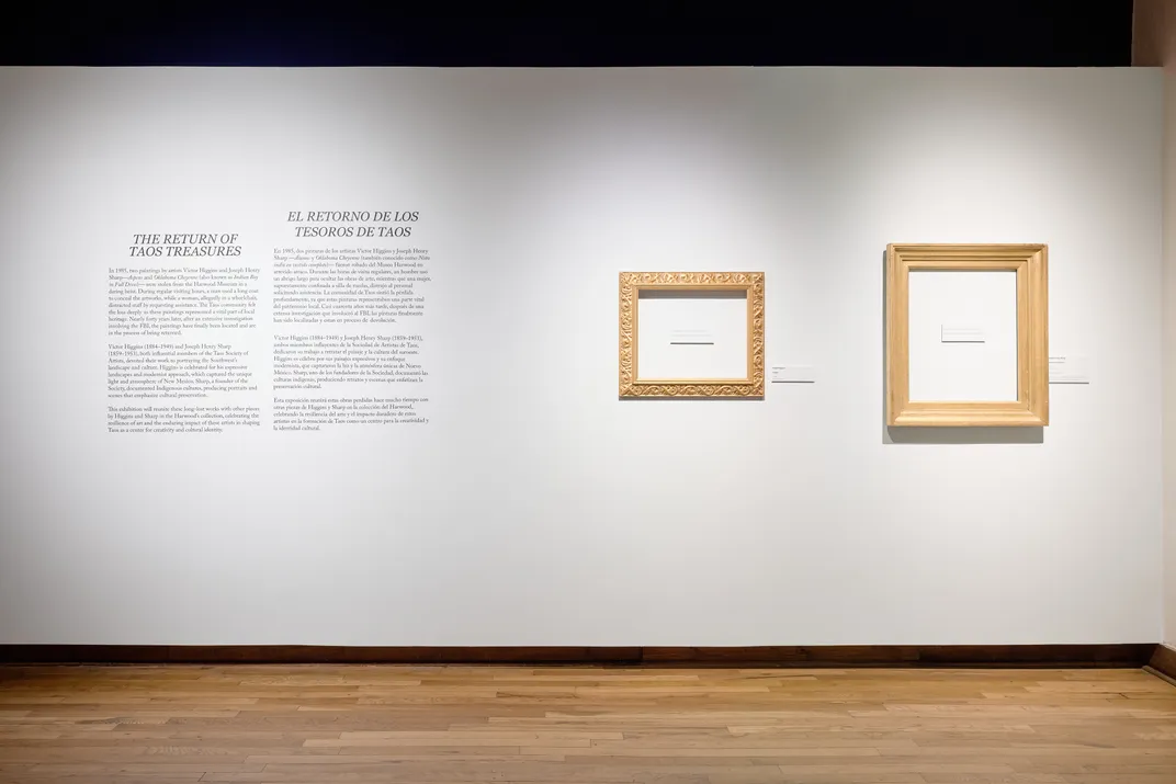 Empty frames on white wall next to some text
