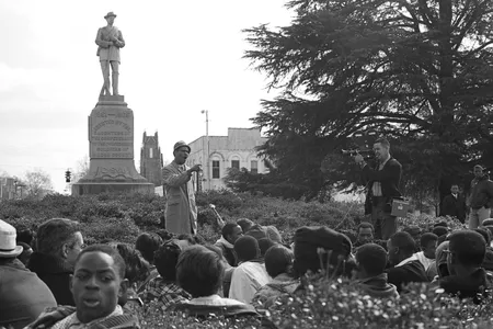 Tuskegee history professor Frank Toland speaks to the gathered students at the base of the Confederate monument.