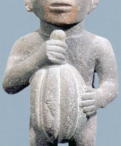 An Aztec figurine holds a cacao pod