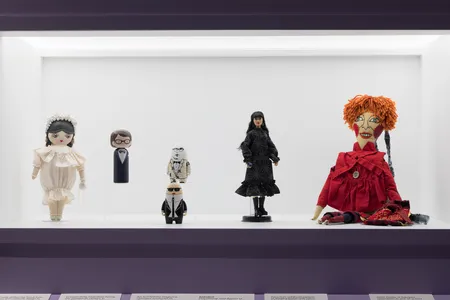 A display case featuring "Dolls as Designers," including Yves Saint Laurent (second from left) and Anna Sui (second from right)