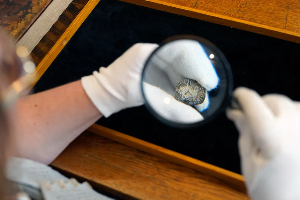 One of the "Lamb of God" coins under a magnifying glass