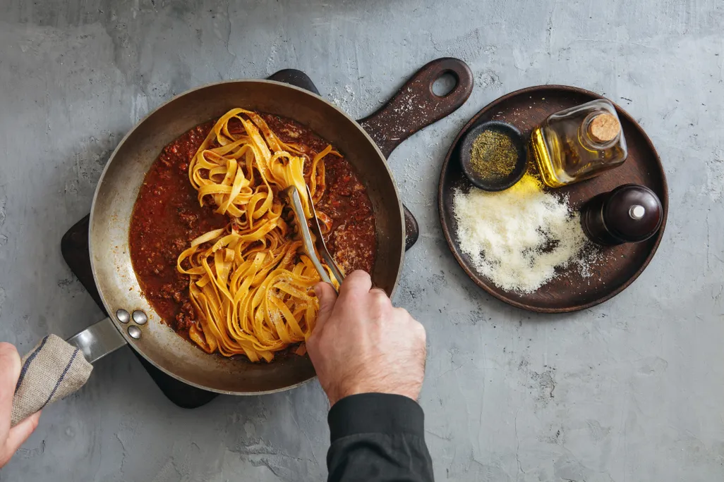 cooking tagliatelle with bolognese
