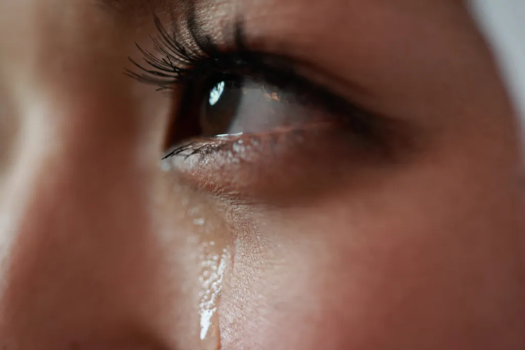 close-up of eye and tear on woman's cheek