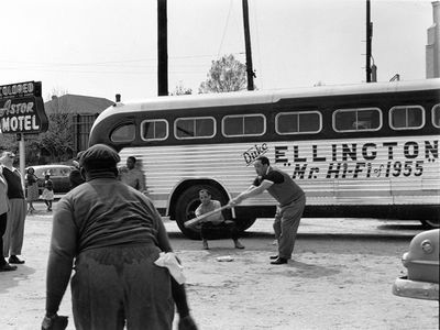 Duke Ellington and band members playing baseball in front of their segregated motel ("Astor Motel") while touring in Florida.