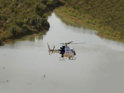 During a patrol of the border between the United States and Mexico, an Air and Marine Operations AS350 AStar helicopter flies low over the Rio Grande.