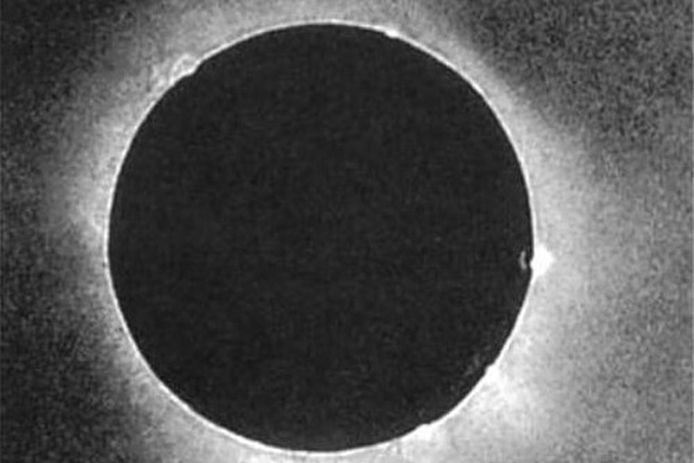 a black and white image of a total solar eclipse, showing the glowing corona around the dark circle of the moon
