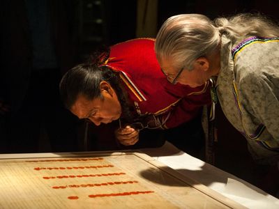 Faithkeeper of the Turtle Clan of the Onondaga Nation of the Haudenosaunee Confederacy Oren Lyons, Ph.D., (right), and The Tadodaho of the Haudenosaunee Confederacy Chief Sidney Hill, examine a treaty at the National Museum of the American Indian